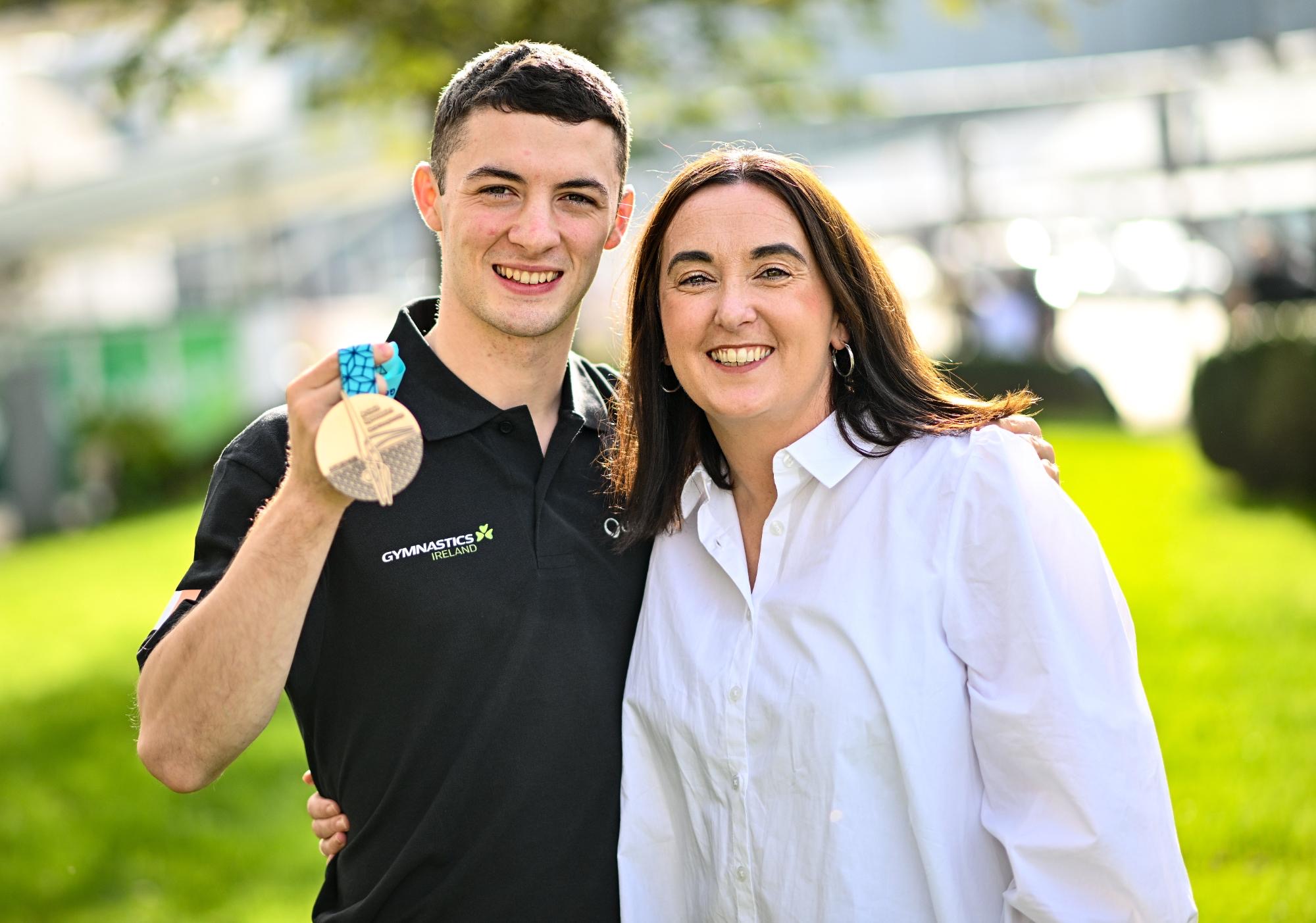 Rhys McClenaghan holding his medal beside GSM founder Sinéad Galvin