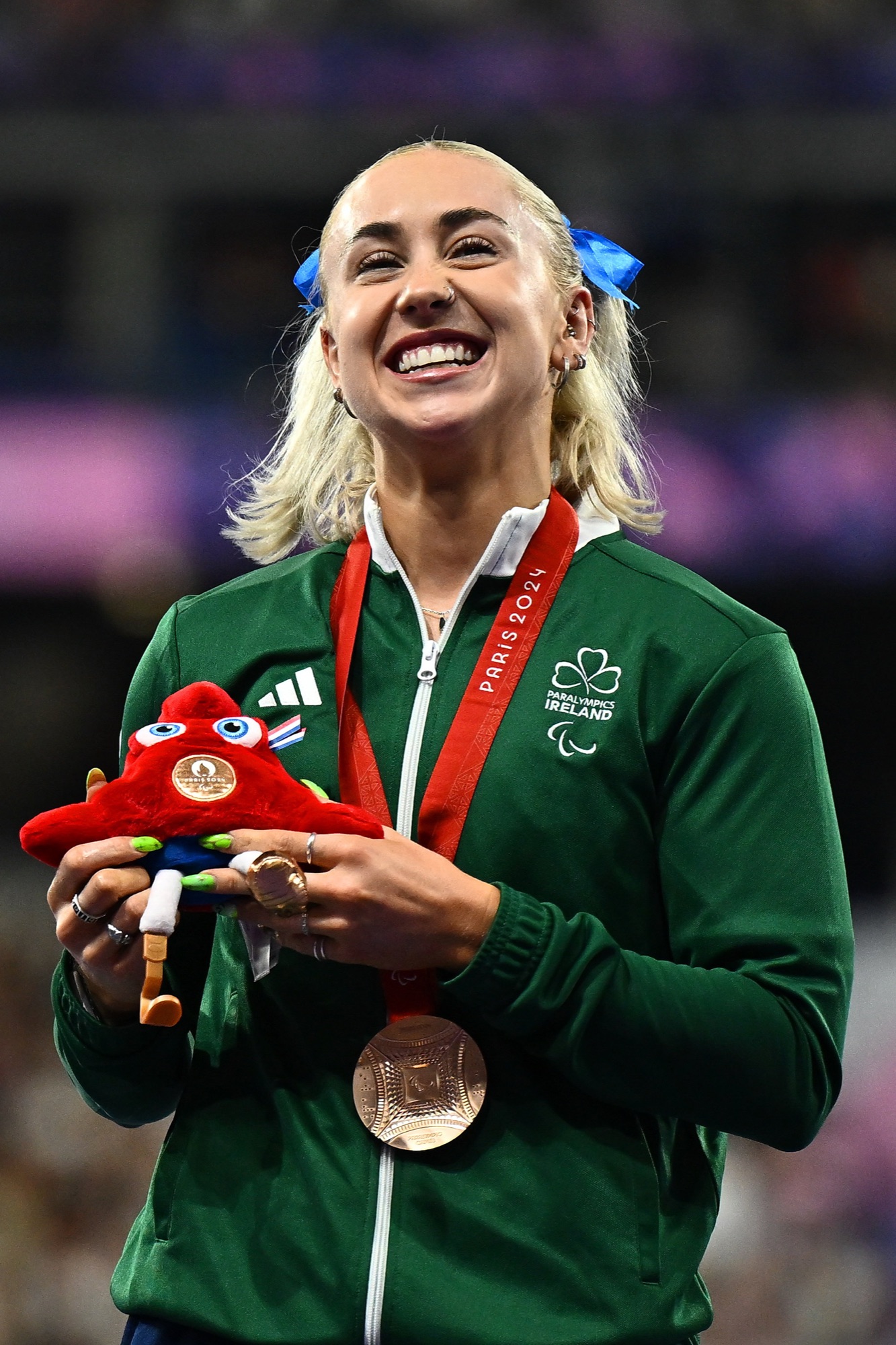 Orla Comerford smiling on the podium with her Paralympic medal