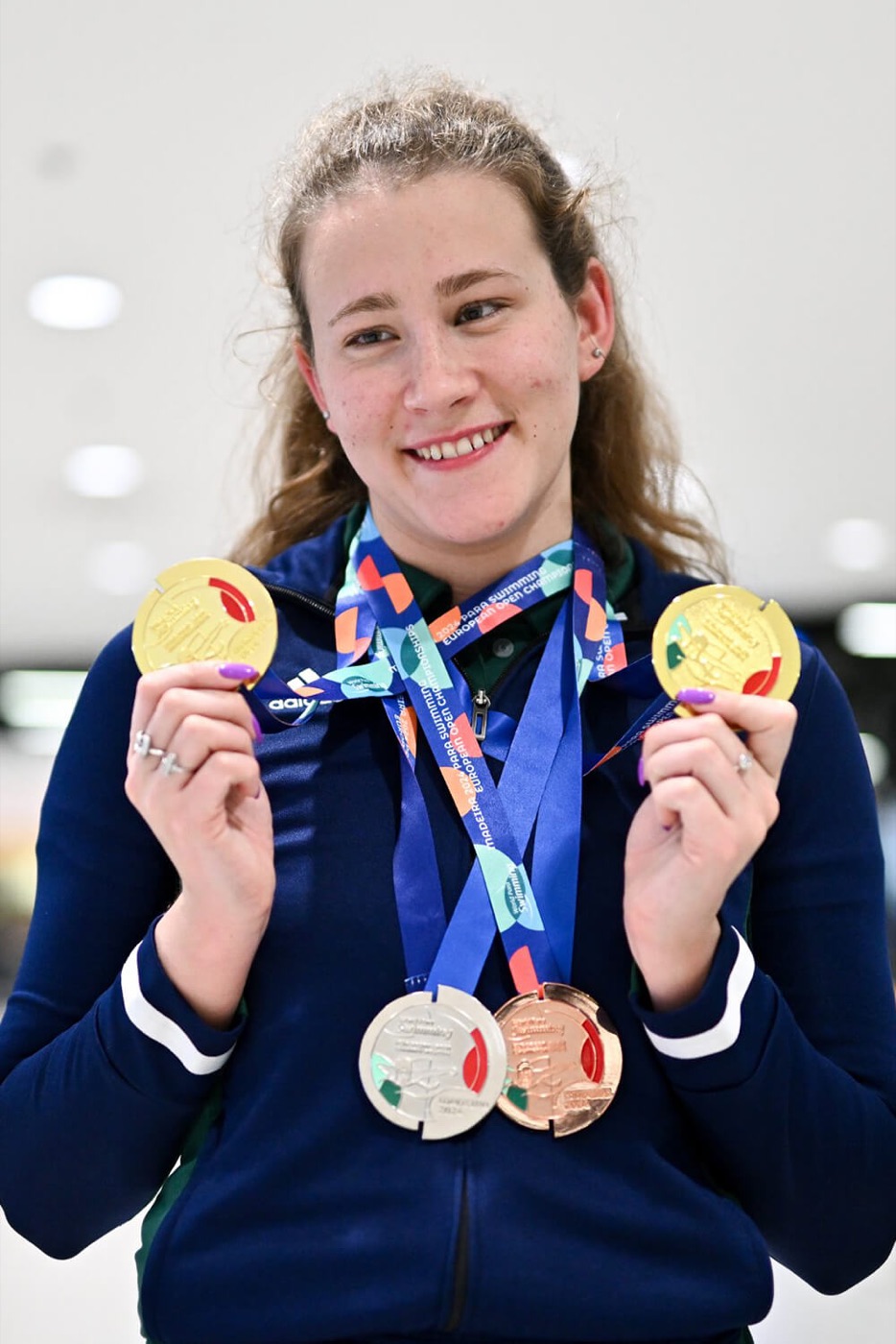 Róisín Ní Riain holding two gold medals